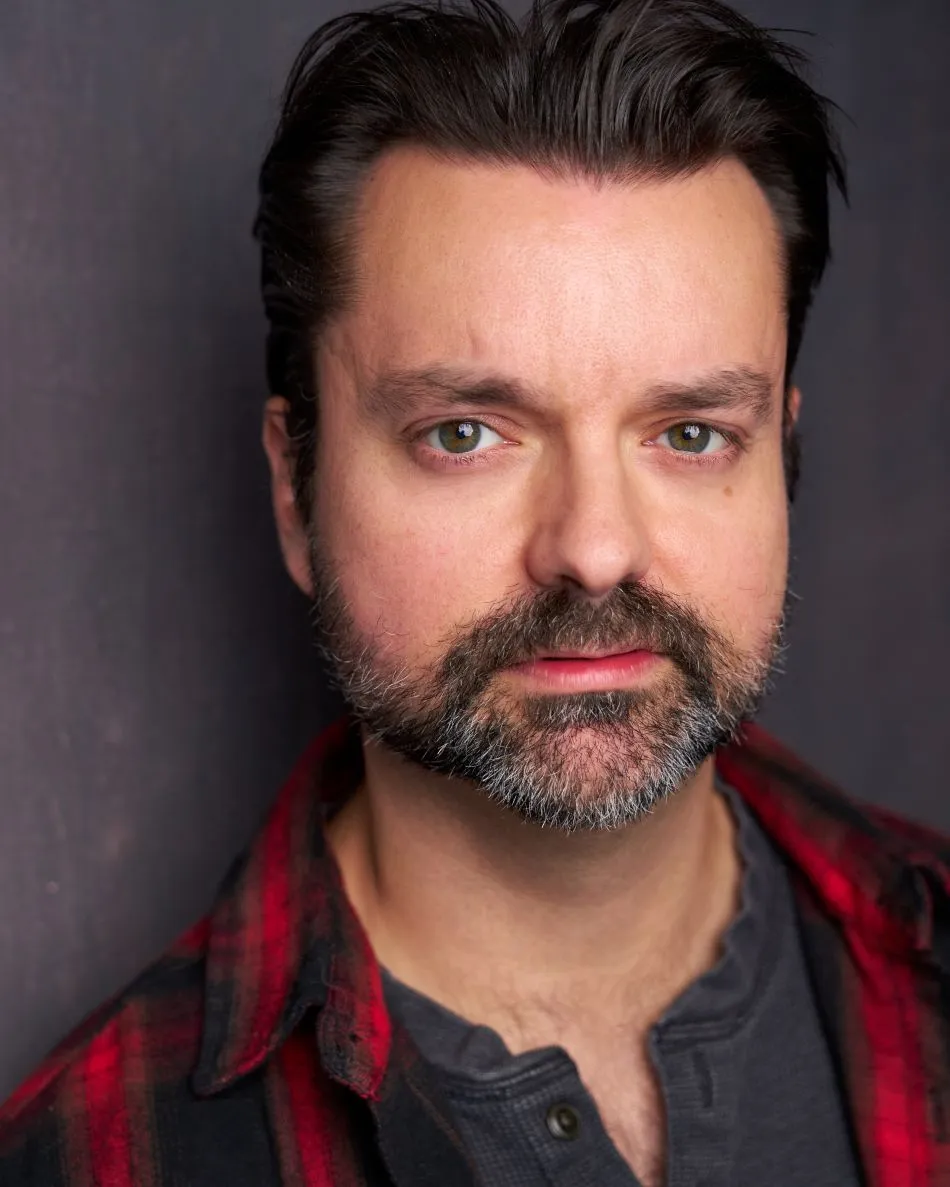 Atlanta actor headshot —male with plaid and henley look, brooding expression, neutral backdrop.