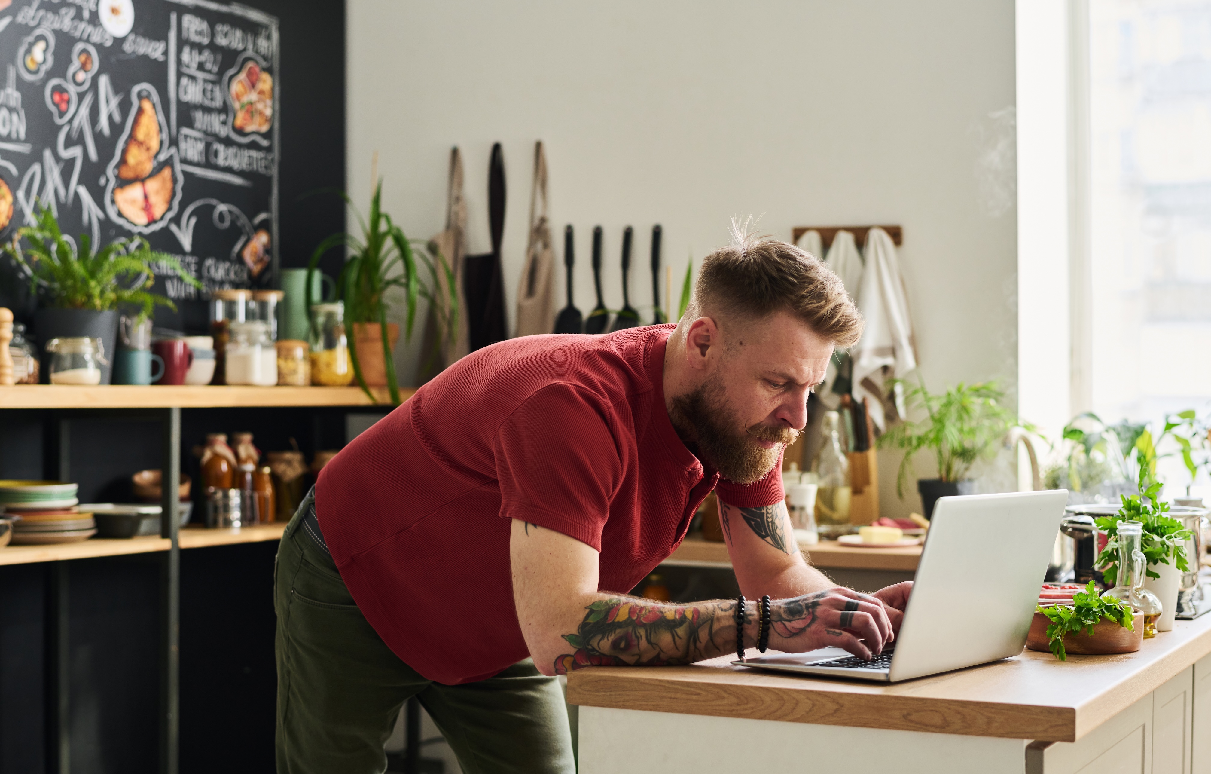 Man using a laptop behind a bar counter
