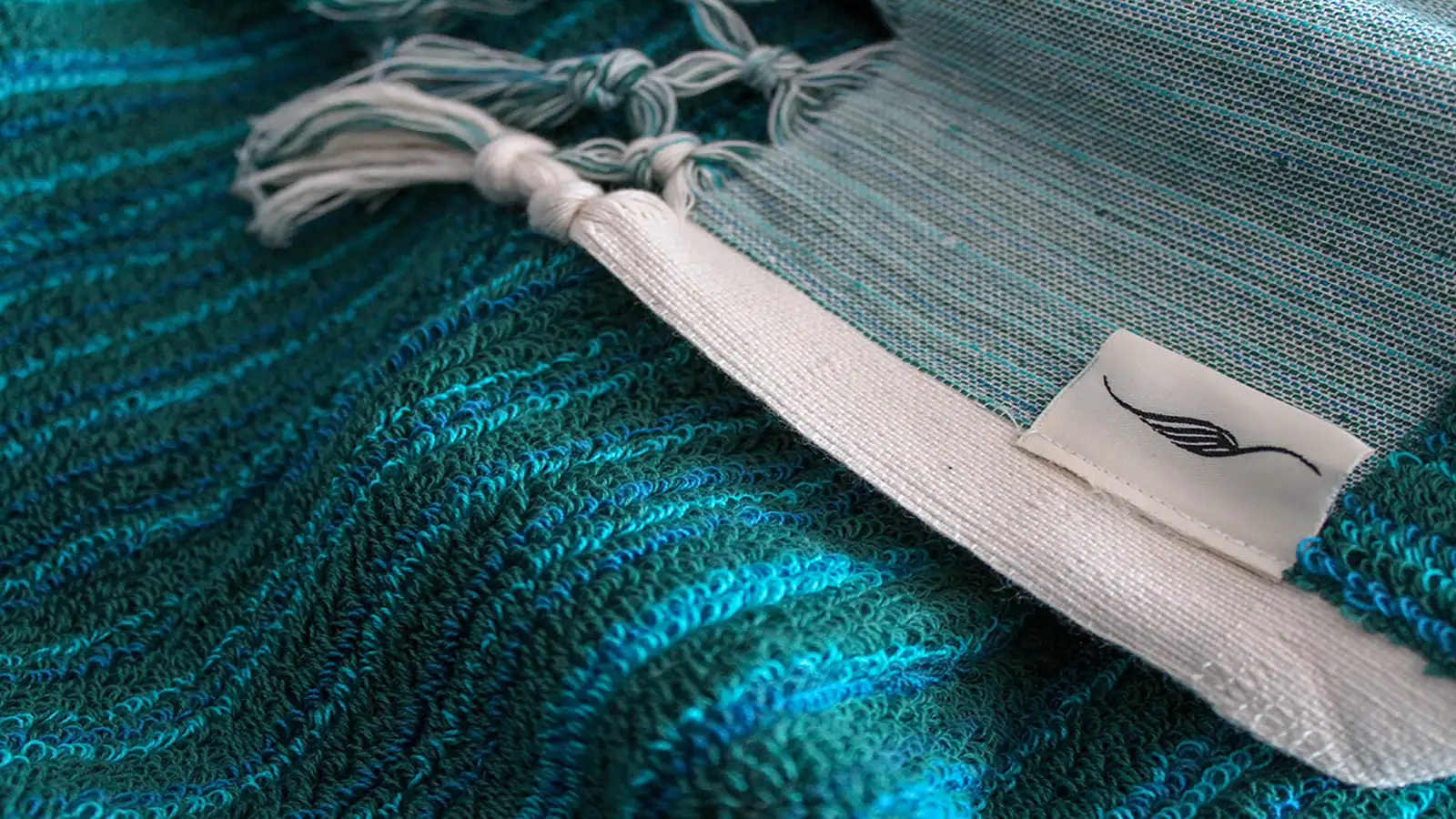 Close-up of handwoven Turkish towel showing thick looped cotton texture in petrol blue
