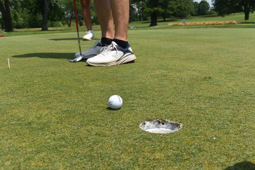 Golf ball being putted into a hole