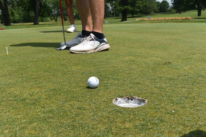 Golf ball being putted into a hole