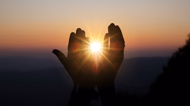hnds holding the sunrise.