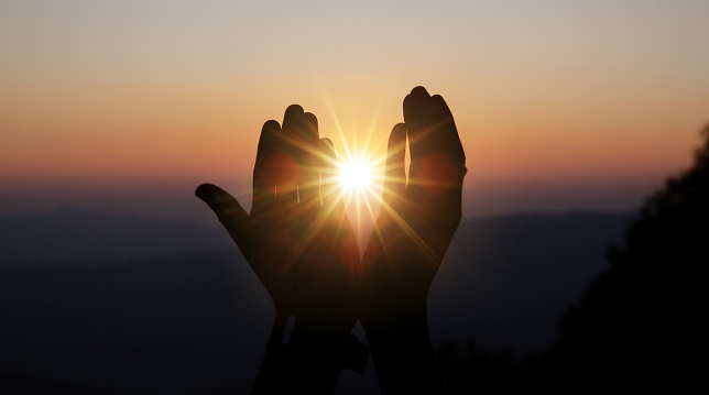 hnds holding the sunrise.