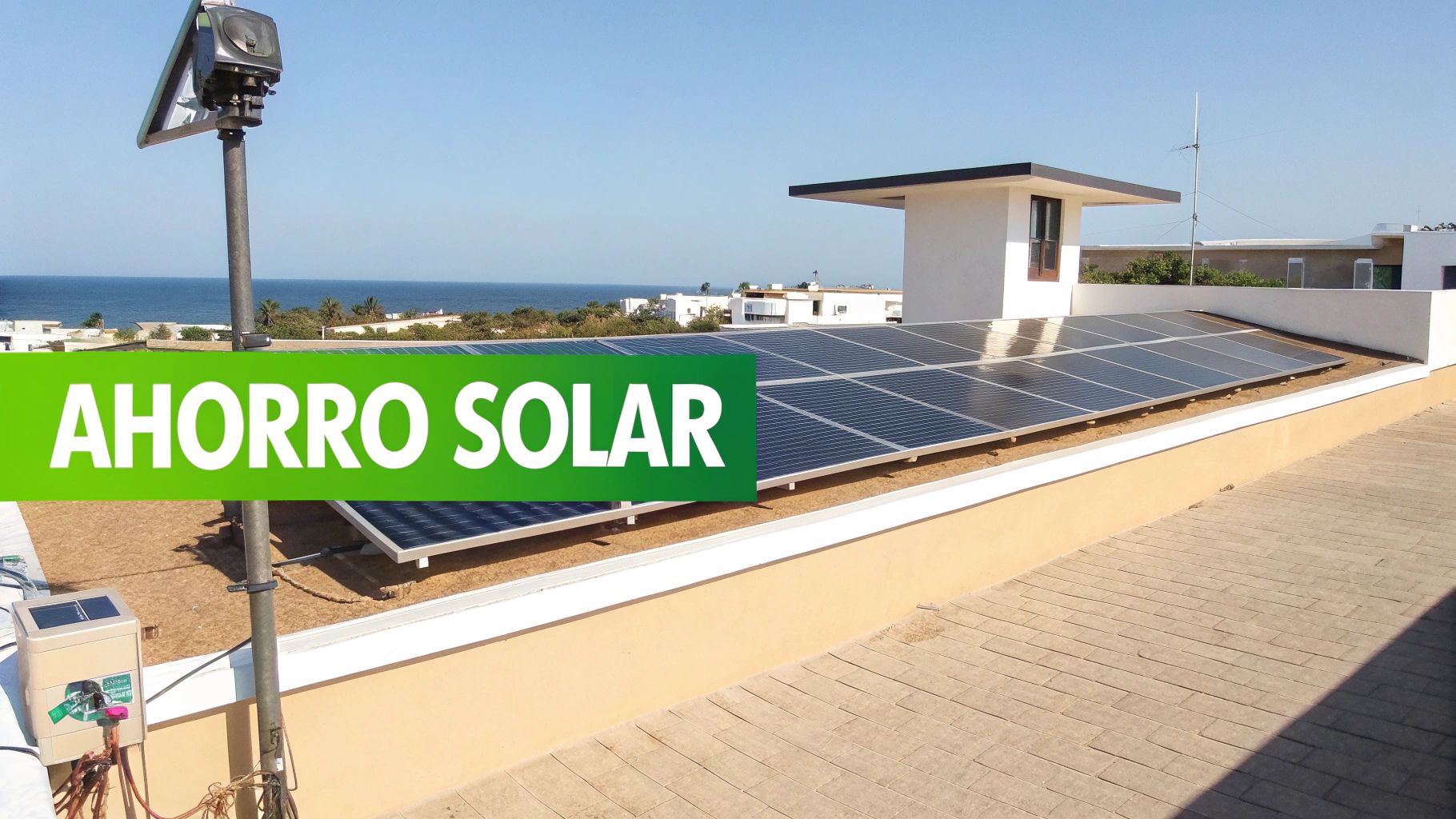 Paneles solares instalados en una azotea con vistas al mar y el texto AHORRO SOLAR.
