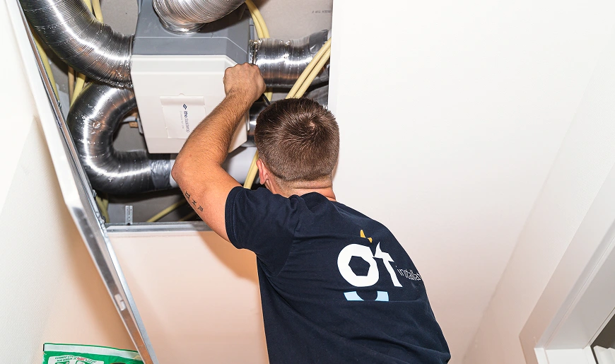 Monteur voert onderhoud uit aan een ventilatiesysteem in een woning.
