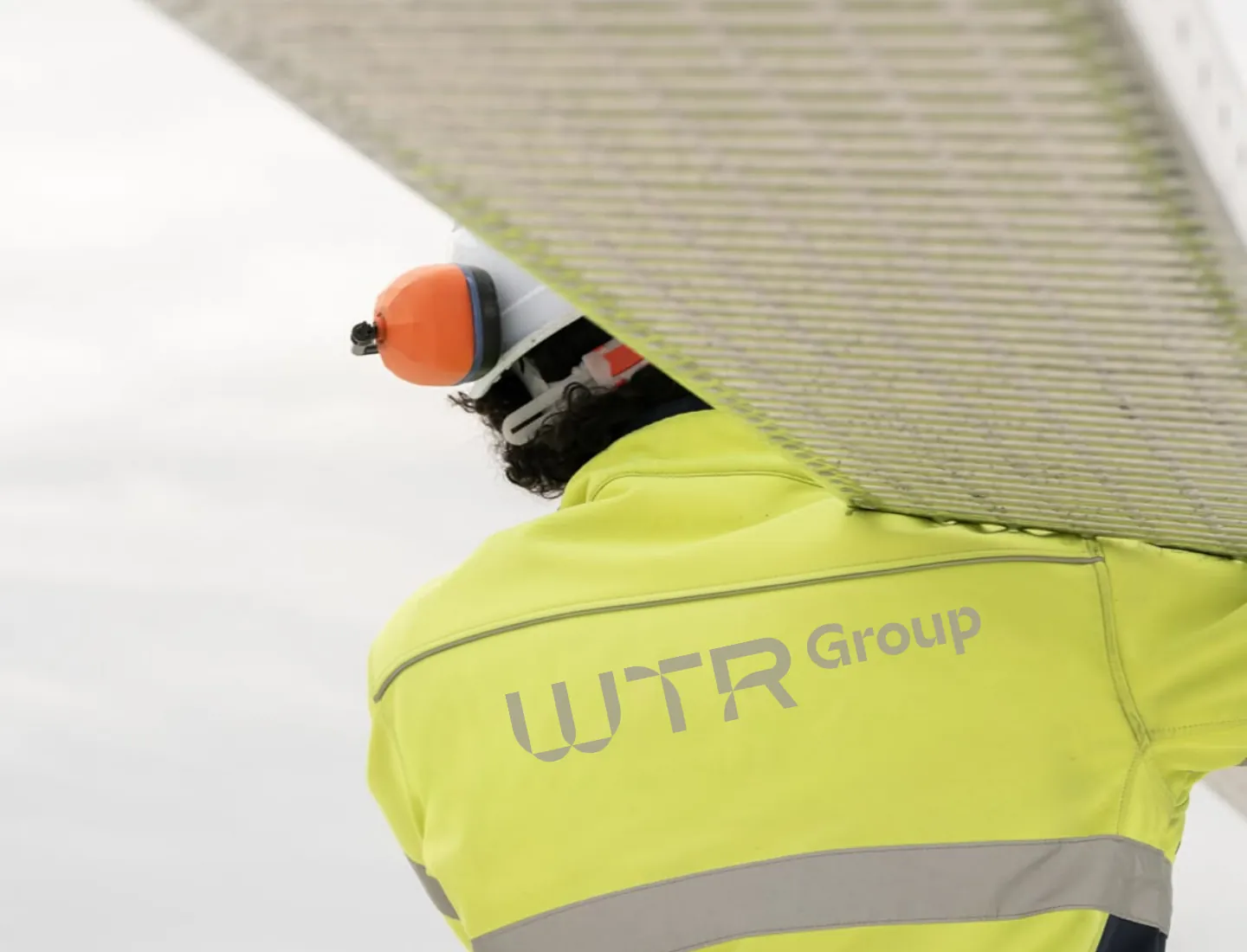 A technician in a WTR Group high-visibility jacket under a lifted filter panel