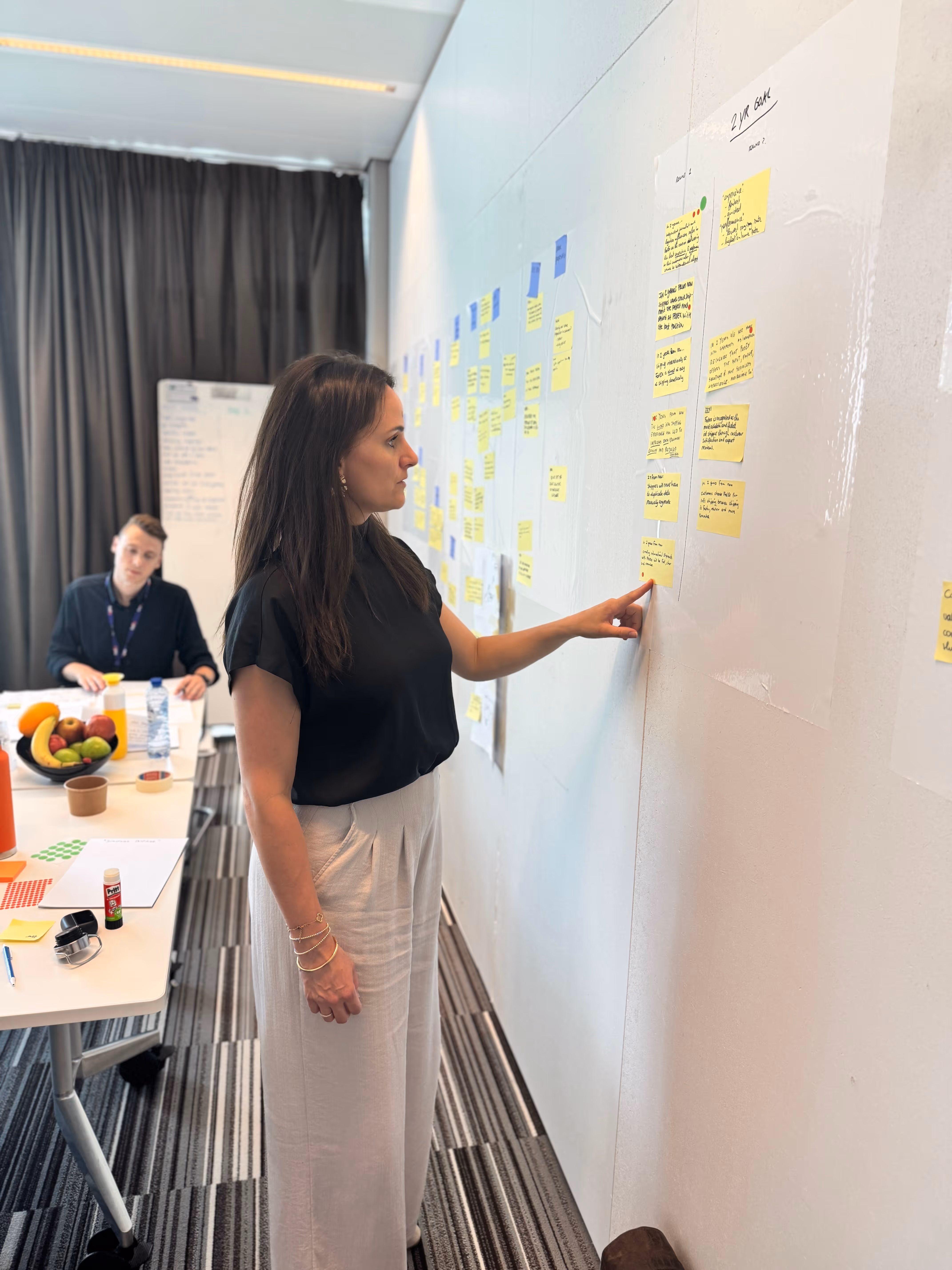 Een facilitator die purpose statements controleert die op een muur hangen
