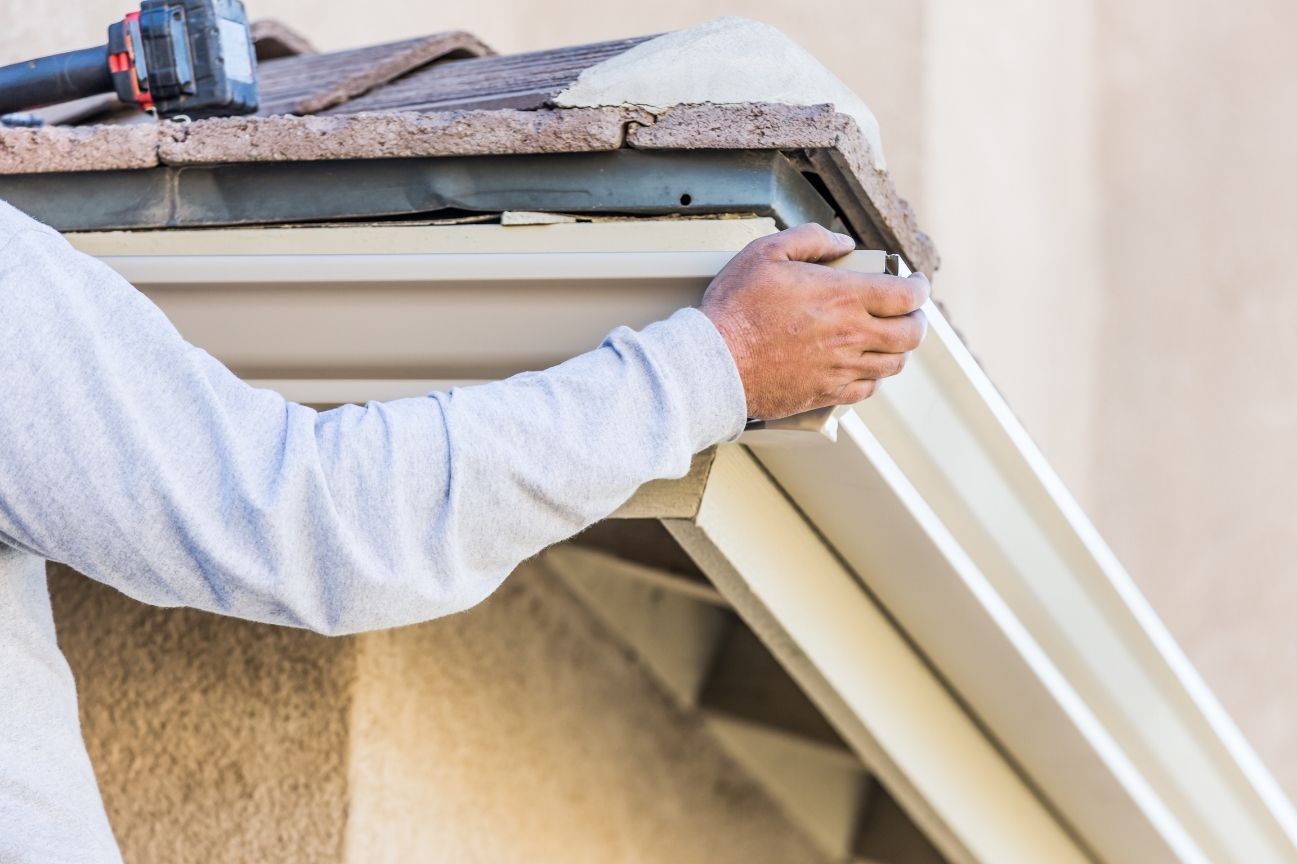 Gutter replacement service removing old fascia board and damaged gutter system