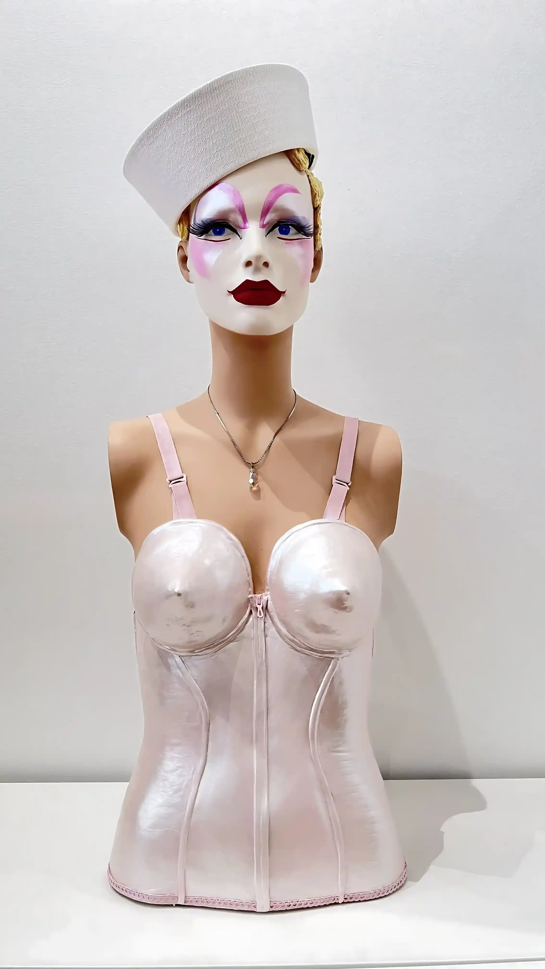 Mannequin-buste nacré, corset conique rose, maquillage runway audacieux, hommage à Vogue, Gaultier, Madonna et Pat McGrath.