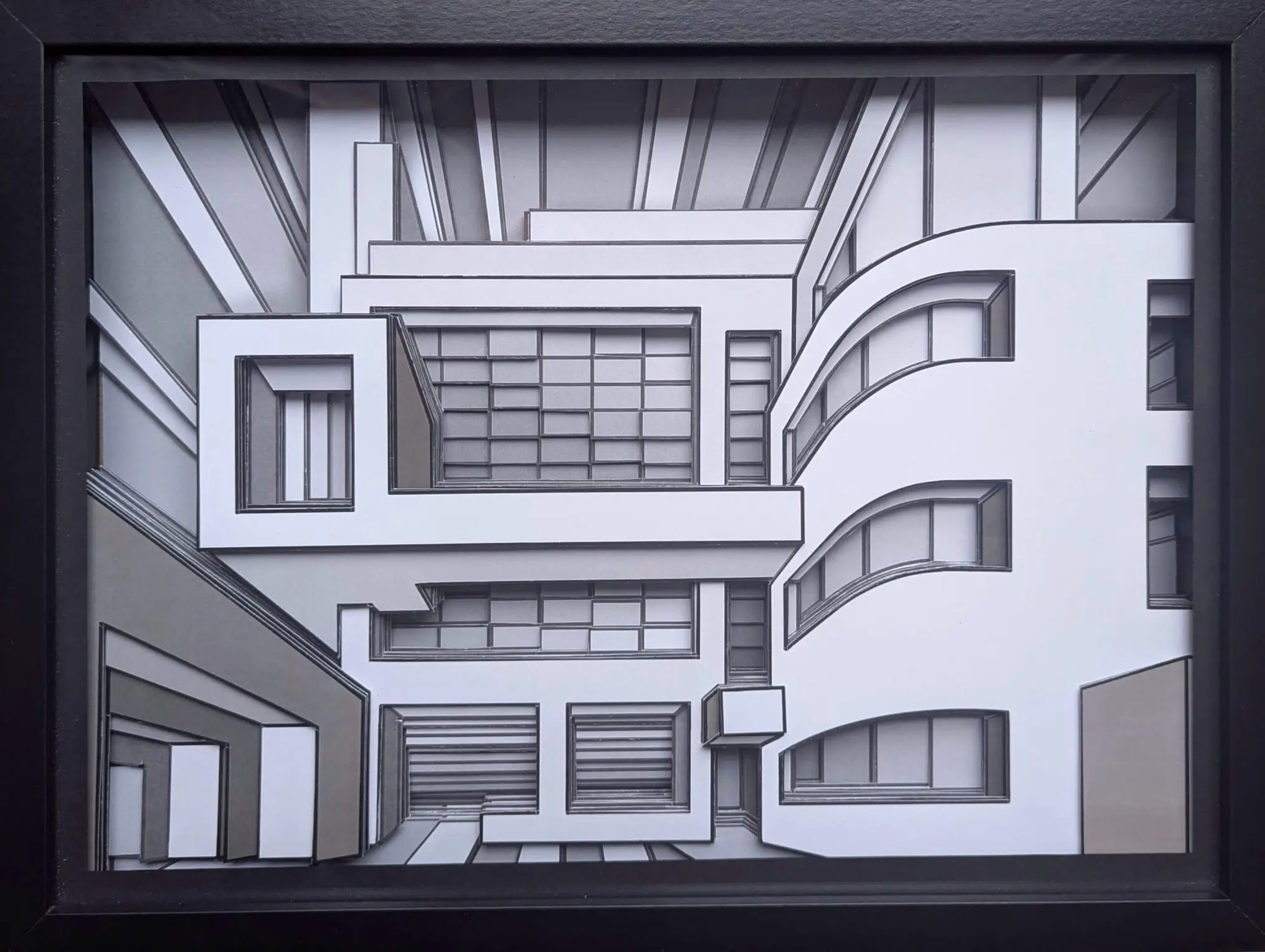 Relief géométrique noir et blanc, volumes imbriqués, lignes nettes, effet architectural en profondeur dans cadre bois.