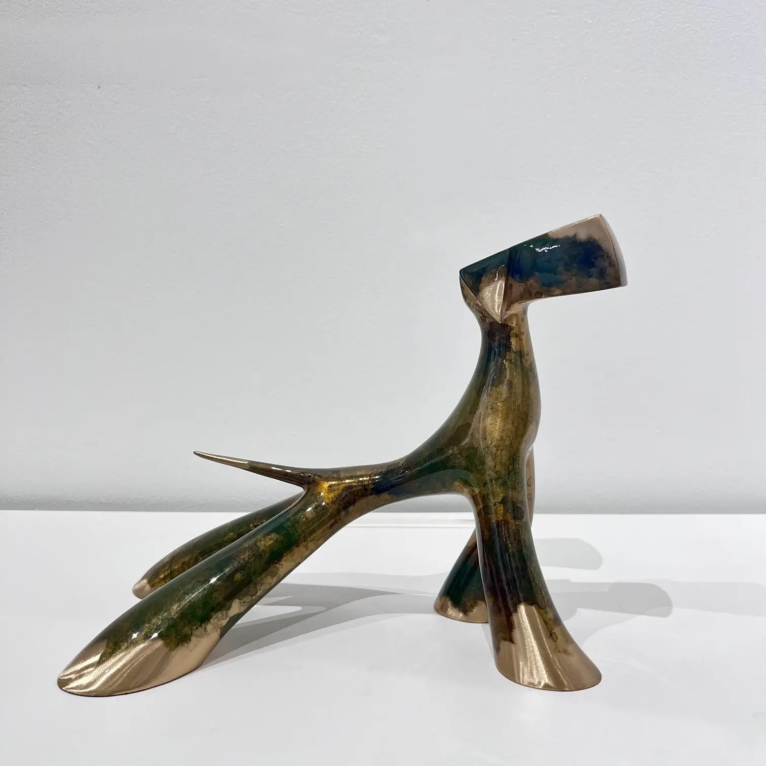 Sculpture compacte vert antique meulé, reflets minéraux, volumes ramassés et brillance profonde.