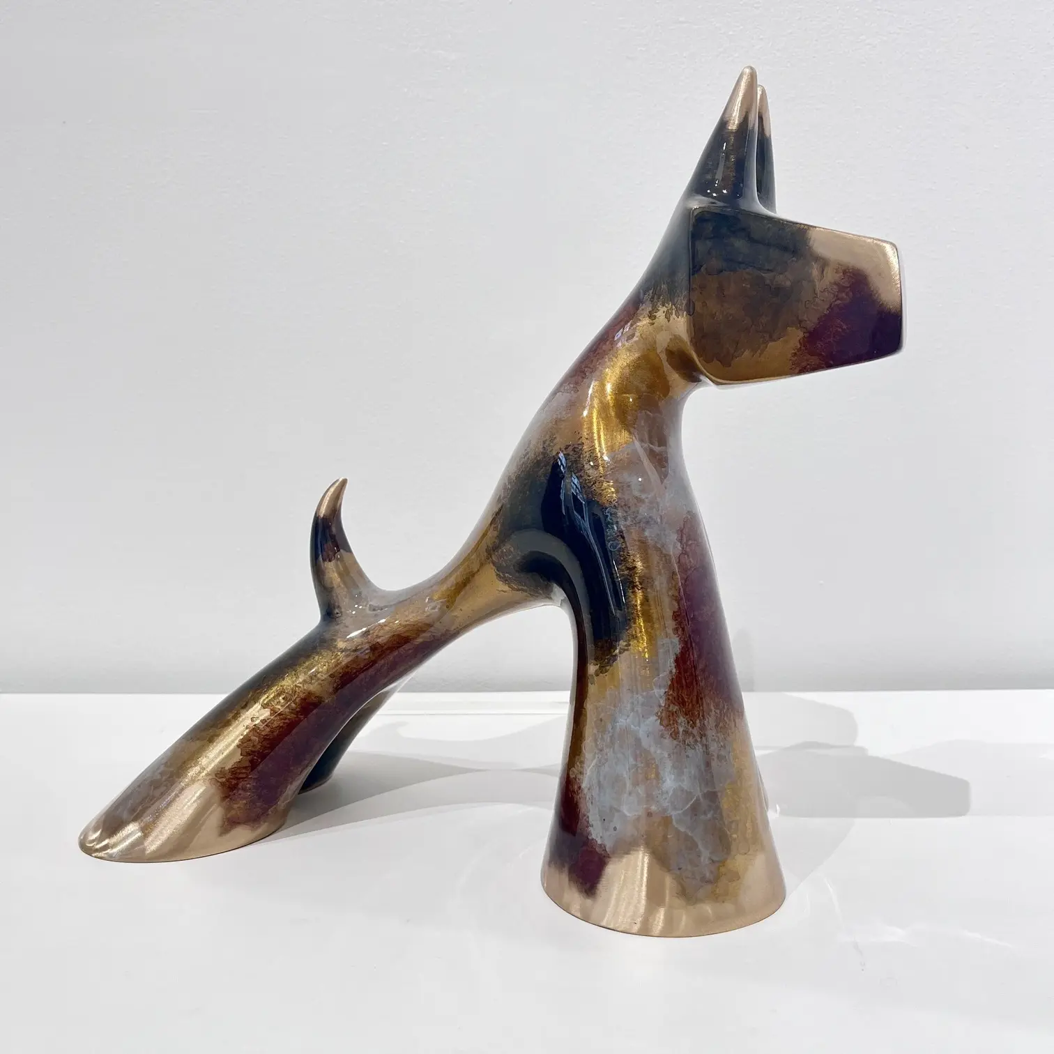 Chien noir marron gris meulé, volumes généreux, reflets ambrés et noirs, finition brillante.