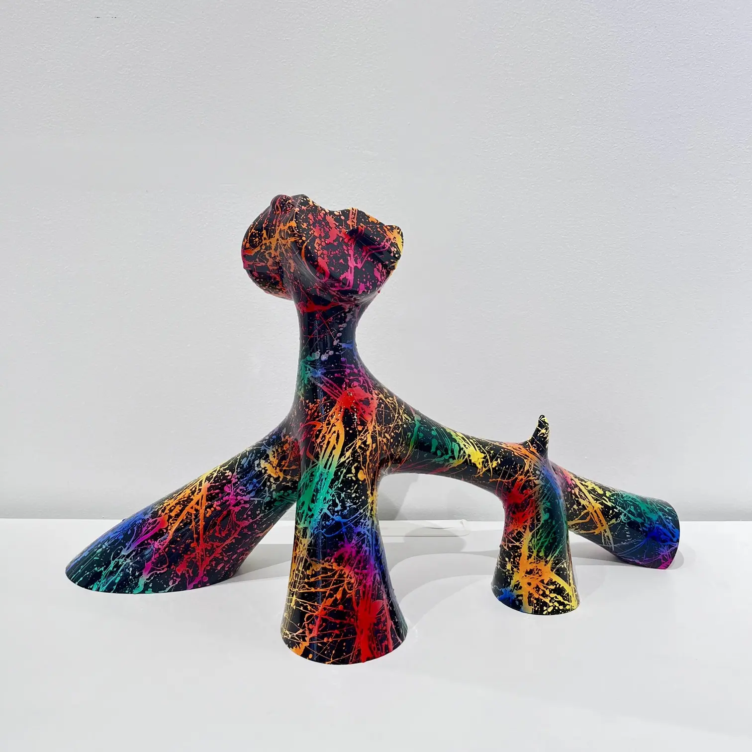 Sculpture street art multicolore, éclats graphiques, drippings vifs, posture verticale et palette urbaine.