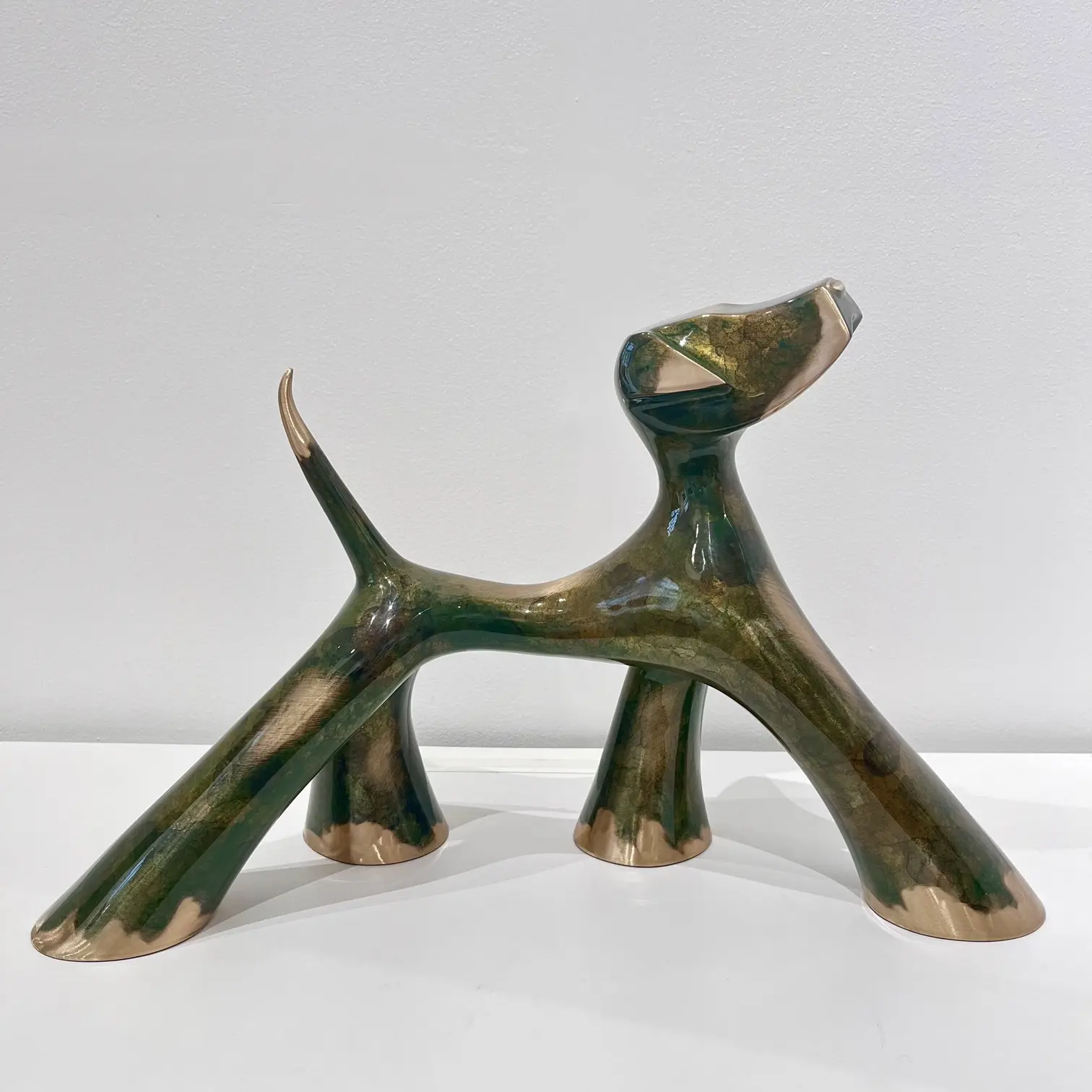 Sculpture vert antique meulé, corps allongé, reflets patinés, queue tendue et volumes étirés.