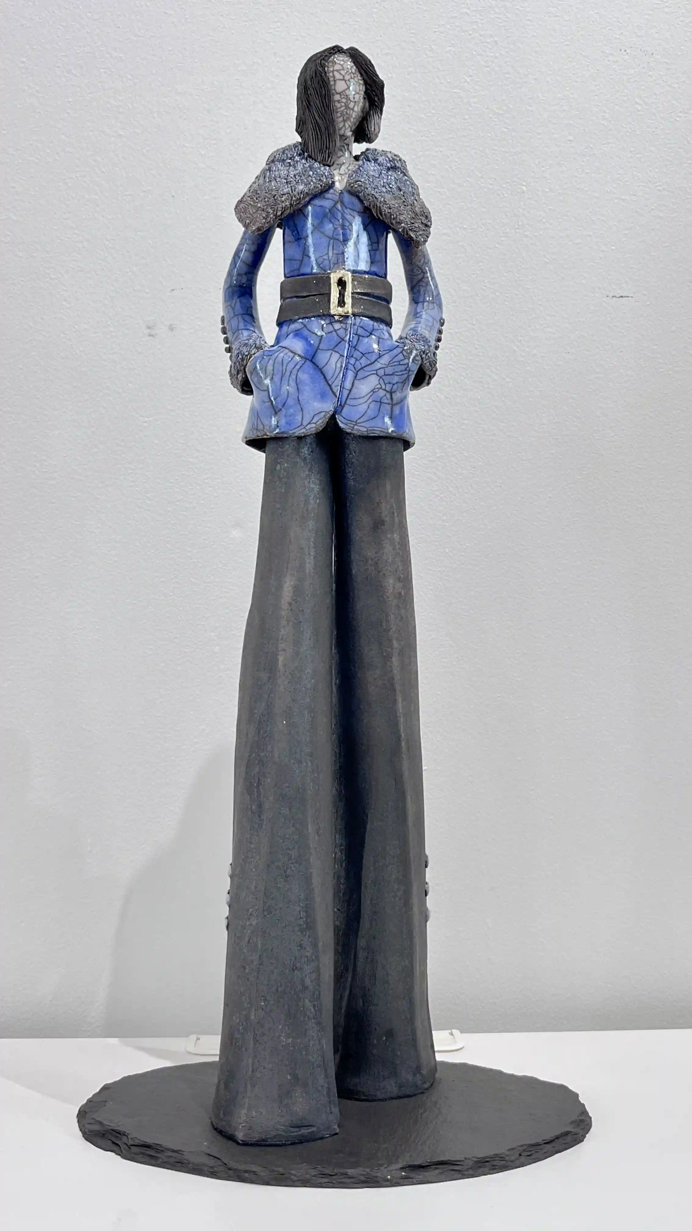 Sculpture violet craquelée, buste cintré à col gris texturé et longues jambes anthracite.