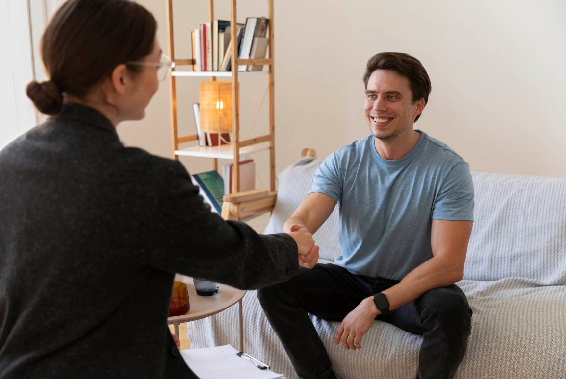 A smiling man shakes hands with a therapist during a counseling session, symbolizing hope, trust, and taking the first step toward recovery in an Oregon rehab program