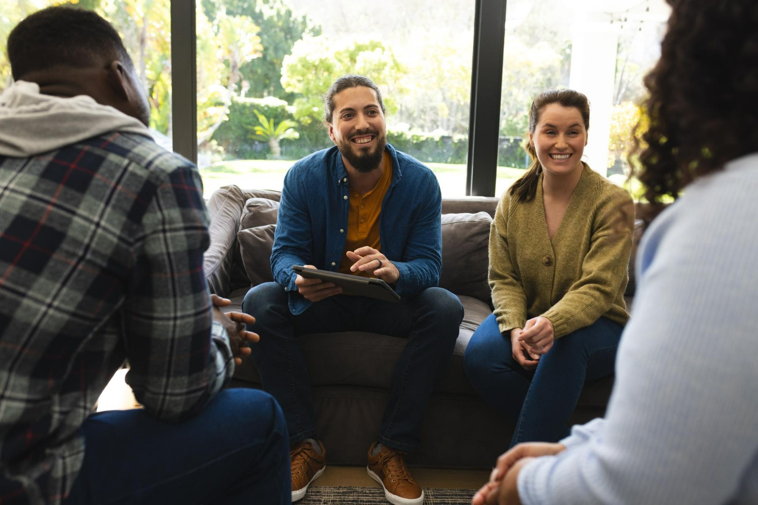 group therapy session with people smiling and talking together