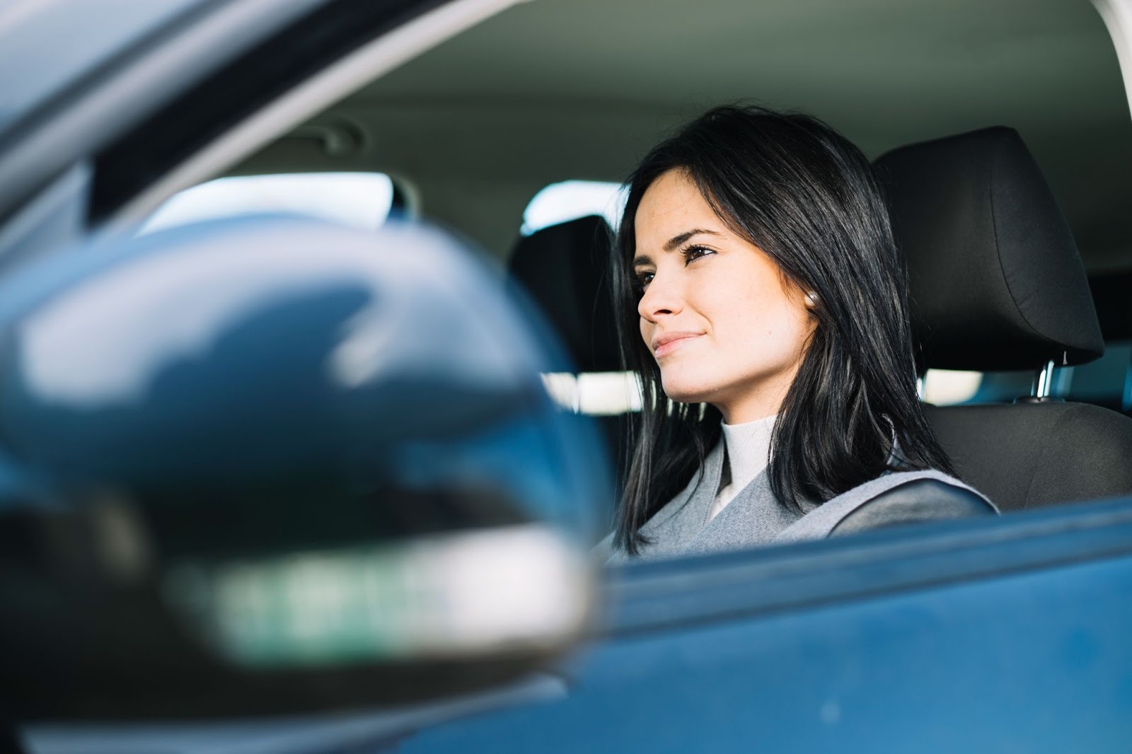Woman sitting in the driver’s seat of a car, representing driving and legal considerations related to a DUII
