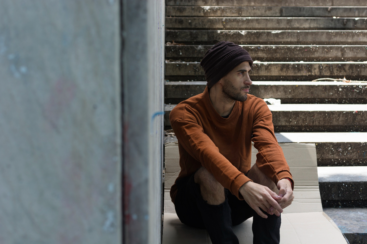 Person sitting alone outdoors, reflecting on addiction recovery and the importance of early relapse prevention and support.