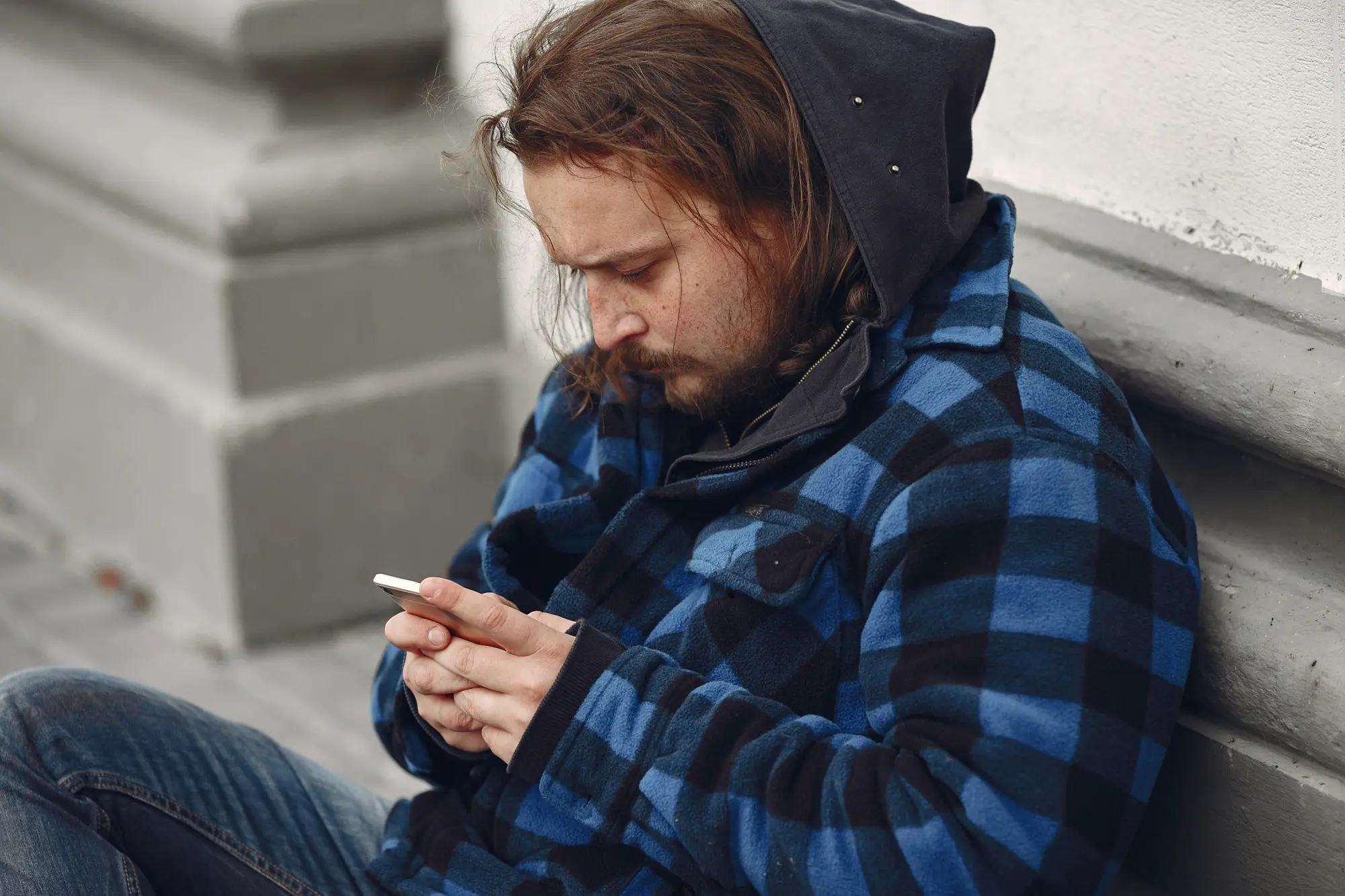 A man experiencing mental health and substance use challenges searches for support on his phone.