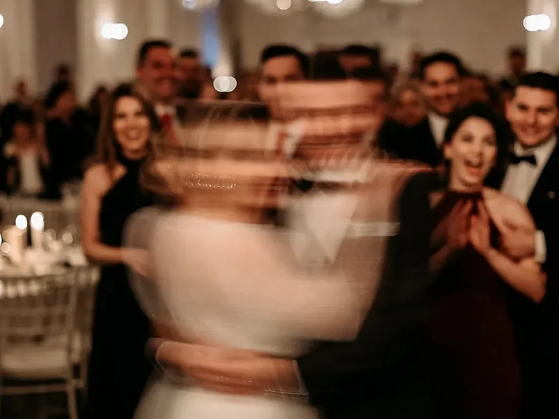 A couple blurred in motion on the dance floor as wedding guests watch