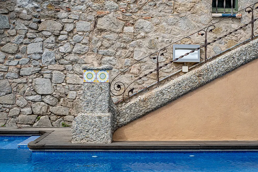 Primer plano de una escalera que da una piscina de estilo modernista.