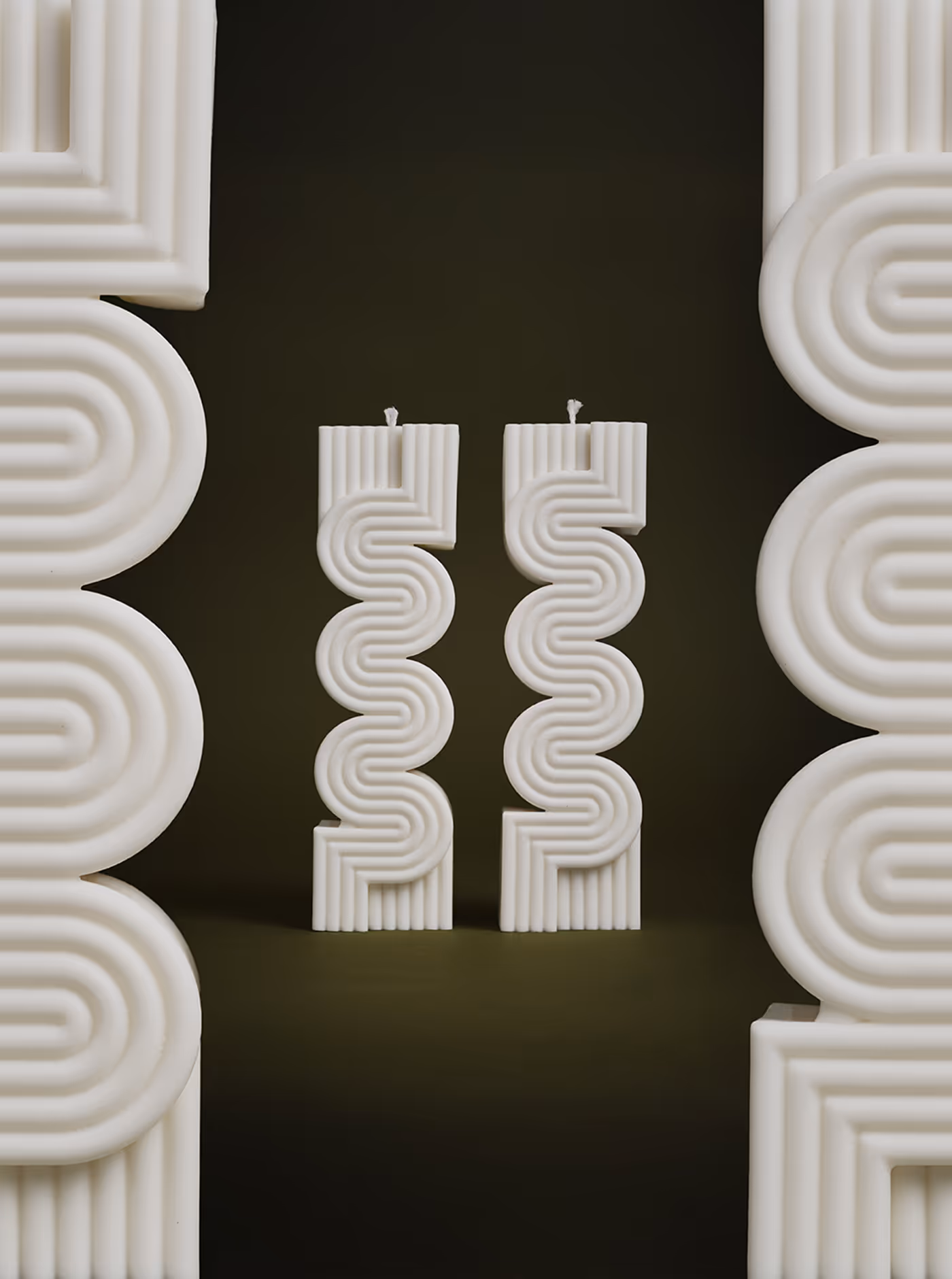 Un par de botas de lluvia Hunter negras y brillantes fotografiadas sobre un fondo naranja vibrante, con el logotipo de la marca "HUNTER" destacado en rojo y blanco.