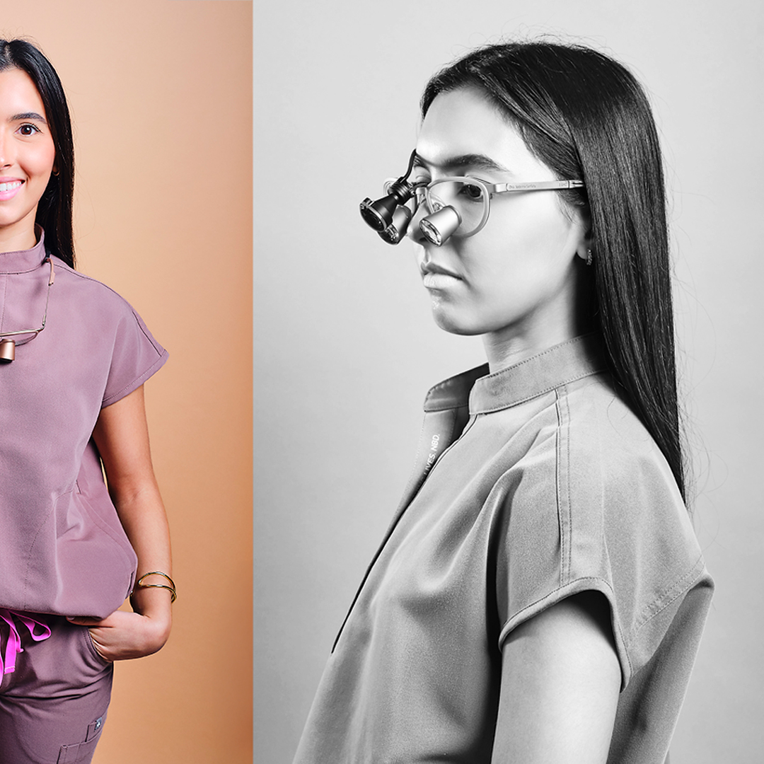 Side profile studio portrait in black and white of a woman with long dark hair wearing translucent glasses, photographed against a soft background.