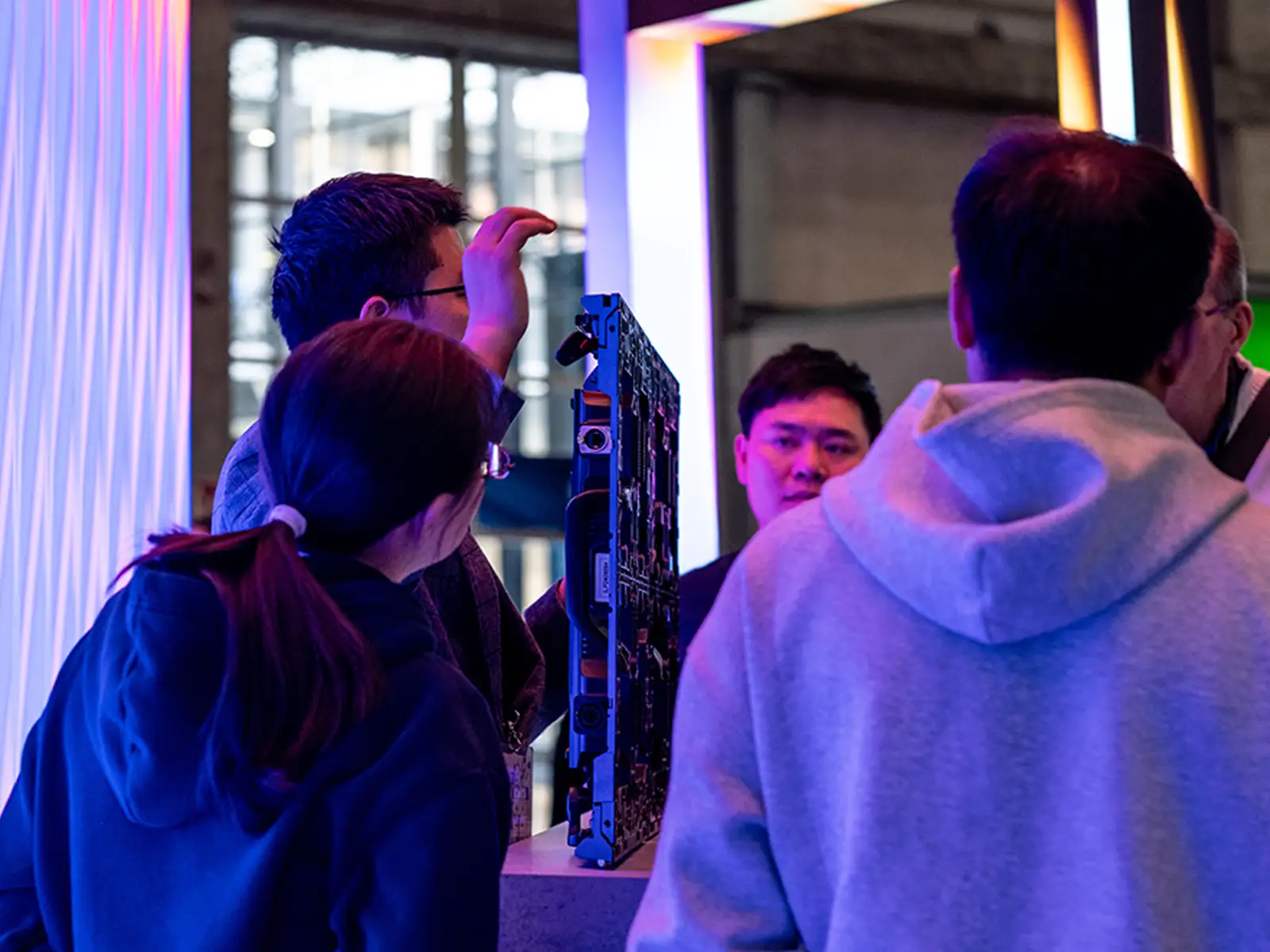 Espacios divididos de comedor y baño. A la izquierda, un comedor con sillas beige y una mesa redonda de madera sobre un suelo de patrones intrincados, con una gran lámpara de arco. A la derecha, un baño minimalista con un lavabo escultórico de piedra y cálida iluminación de acento.