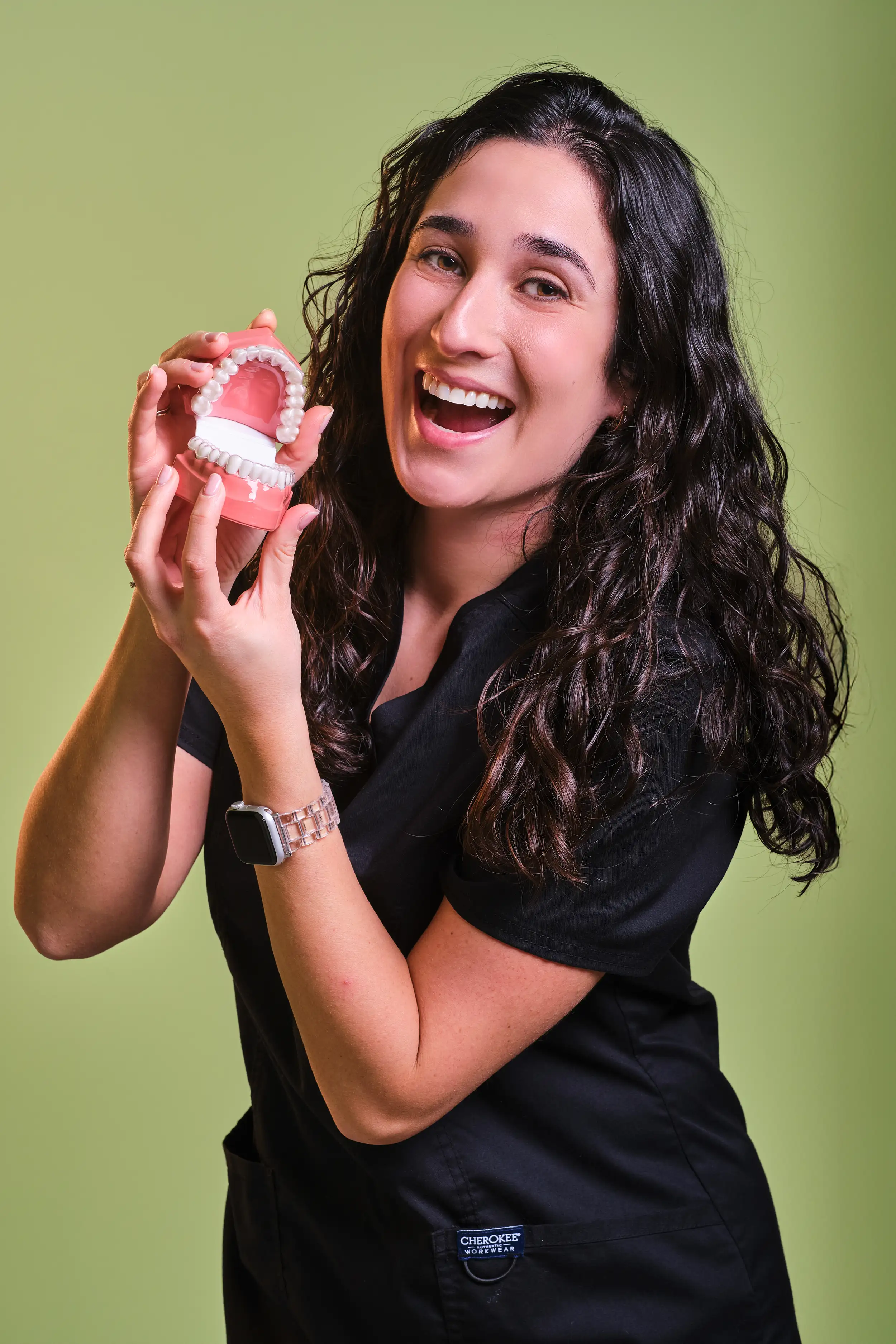 Retrato espontáneo de profesional sanitaria con modelo dental – fotografía corporativa