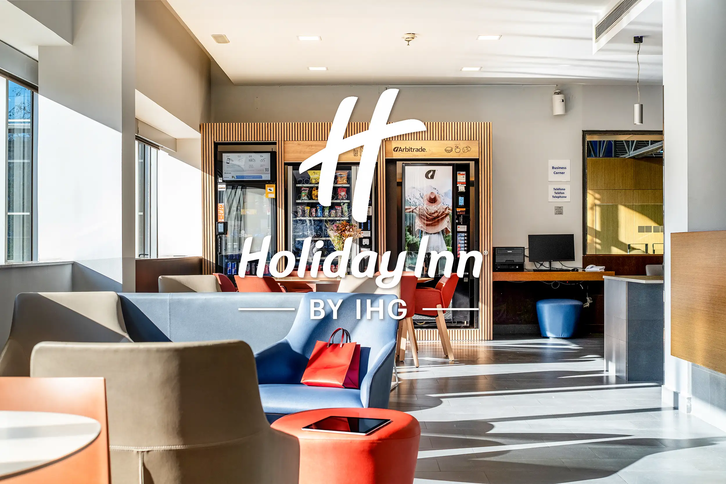 Zona lounge del Holiday Inn Express Barcelona con sofás de diseño, luz natural y espacios amplios para huéspedes