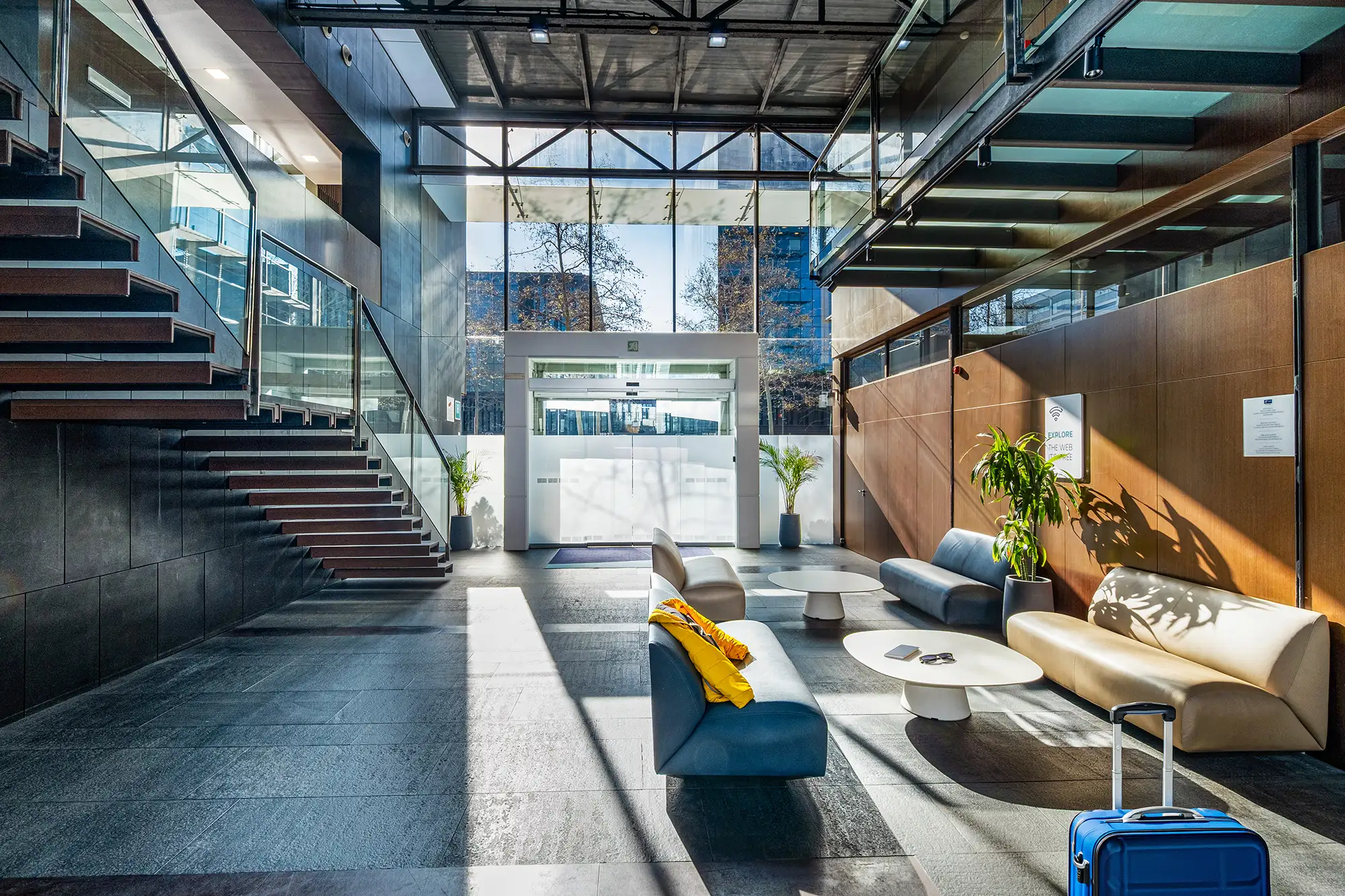 Lobby de un hotel donde atraviesa el sol por las ventanas