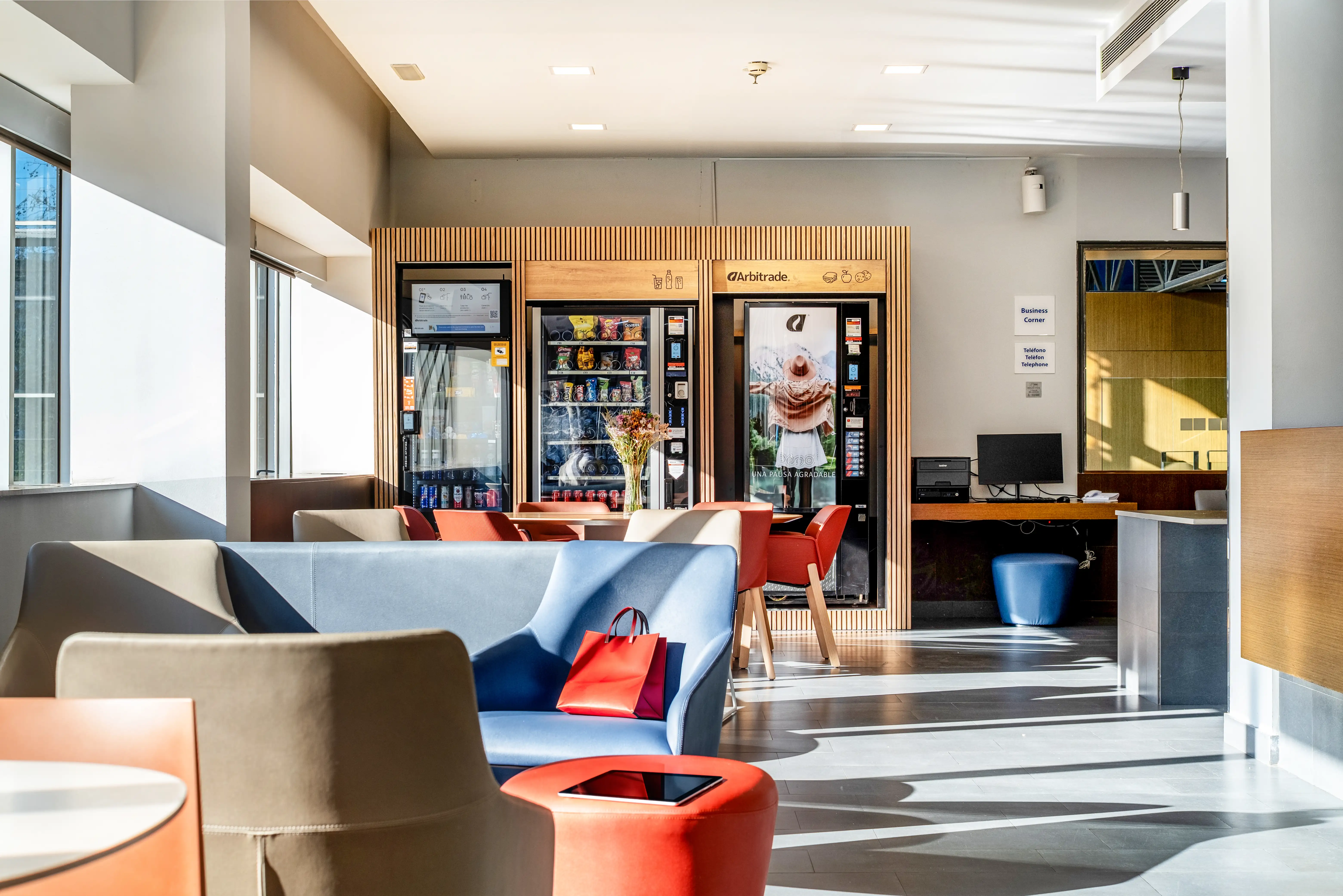 Zona lounge del Holiday Inn Express Barcelona con sofás de diseño, luz natural y espacios amplios para huéspedes