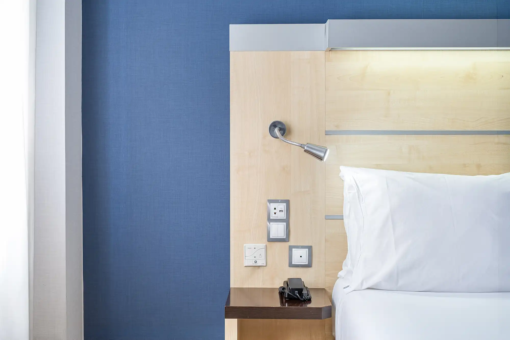 Detalles de una habitacion de hotel con la cama y mesita de noche