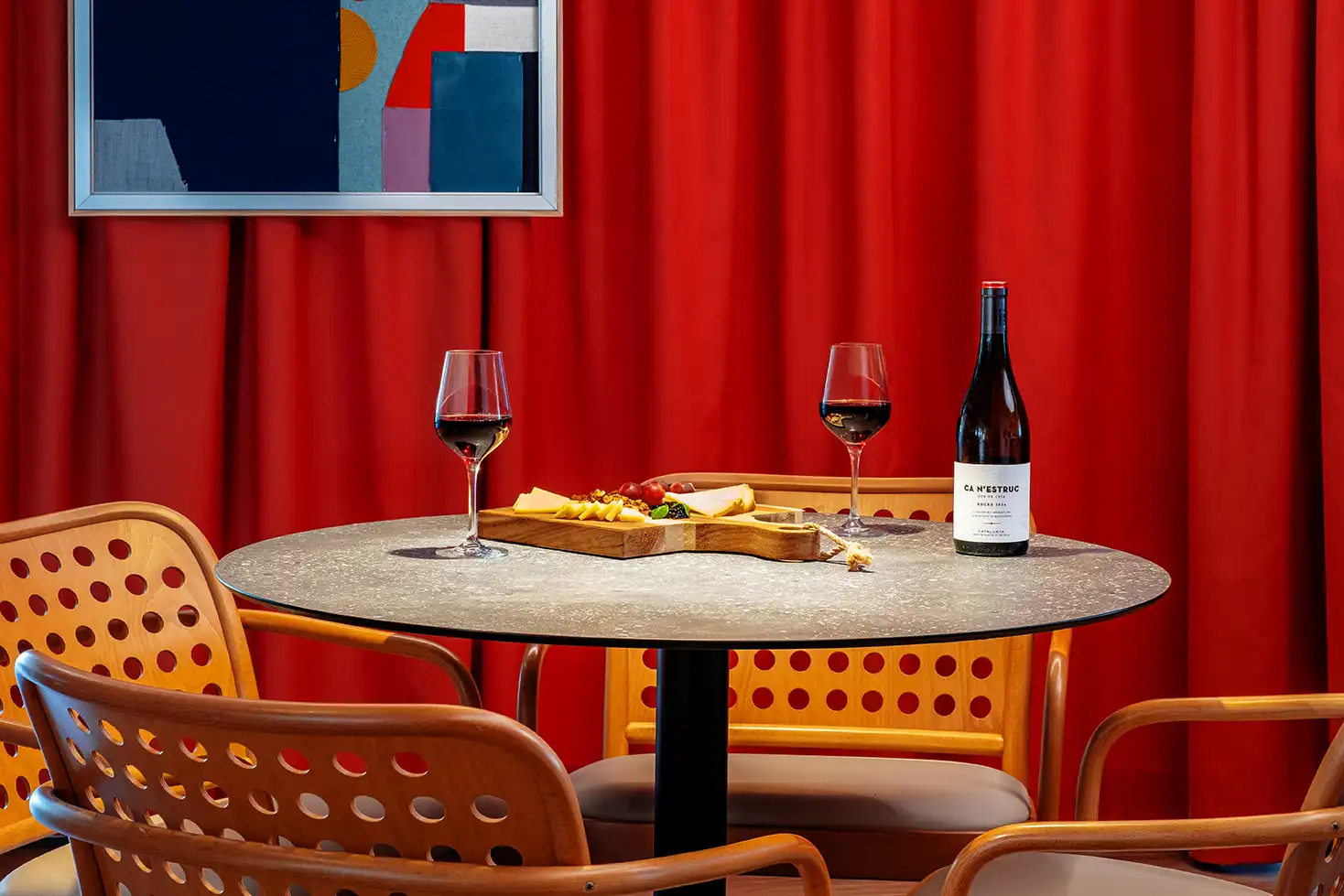 Mesa preparada con pizzas y vino en el restaurante del Ibis Styles Barcelona Sant Joan Despí.