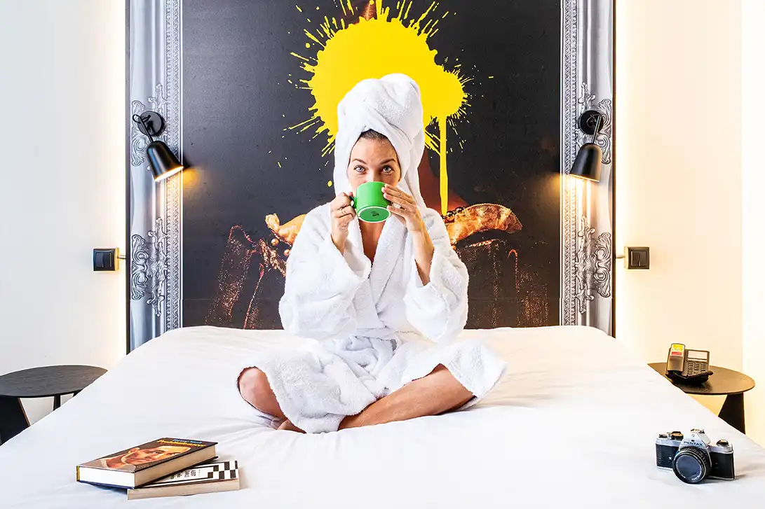 Modelo relajándose sobre la cama de una habitación del Ibis Styles Barcelona Sant Joan Despí.