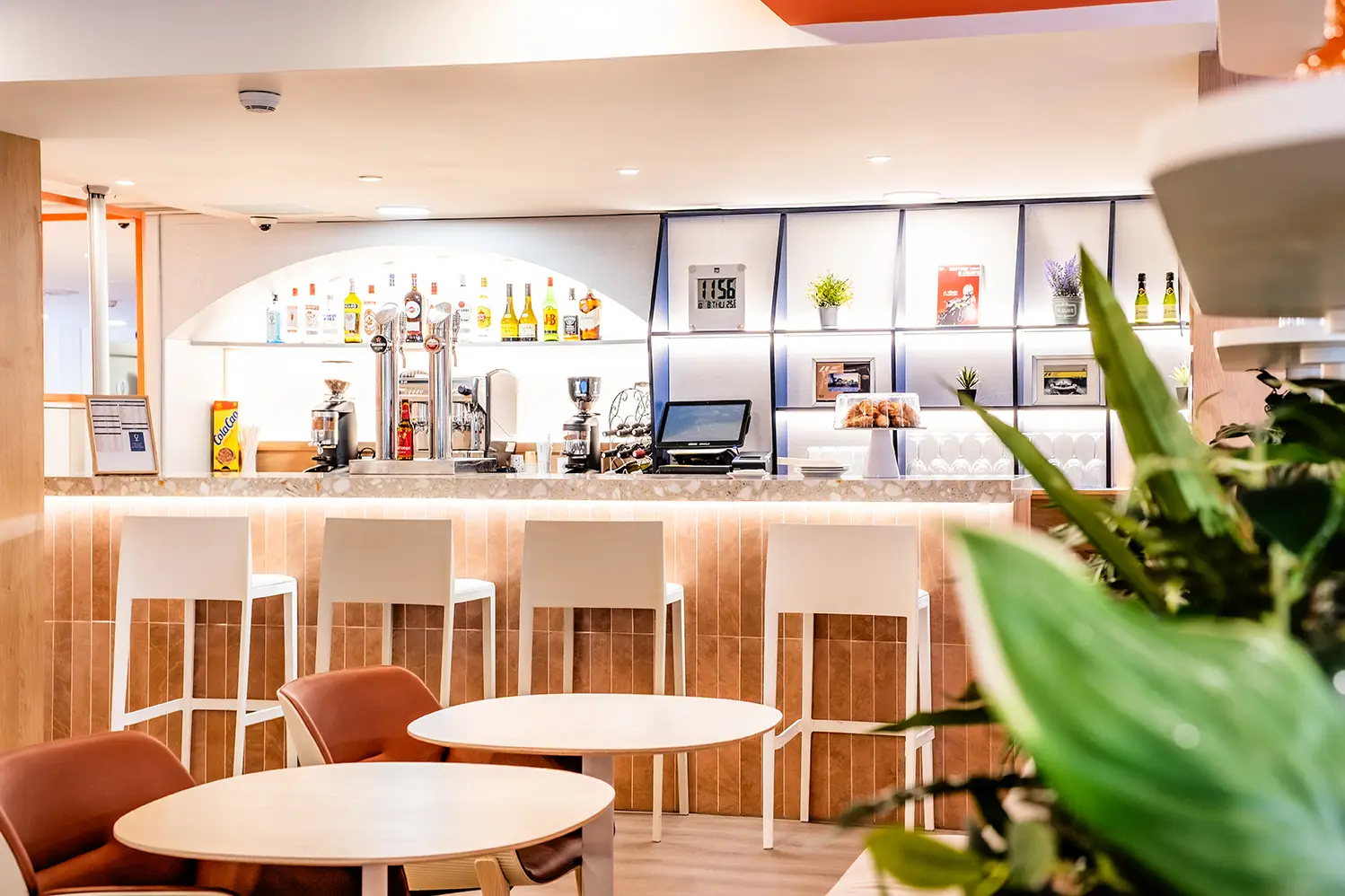 Bar renovado del Hotel Holiday Inn Express Barcelona Montmeló, con barra iluminada, taburetes y zona de descanso.
