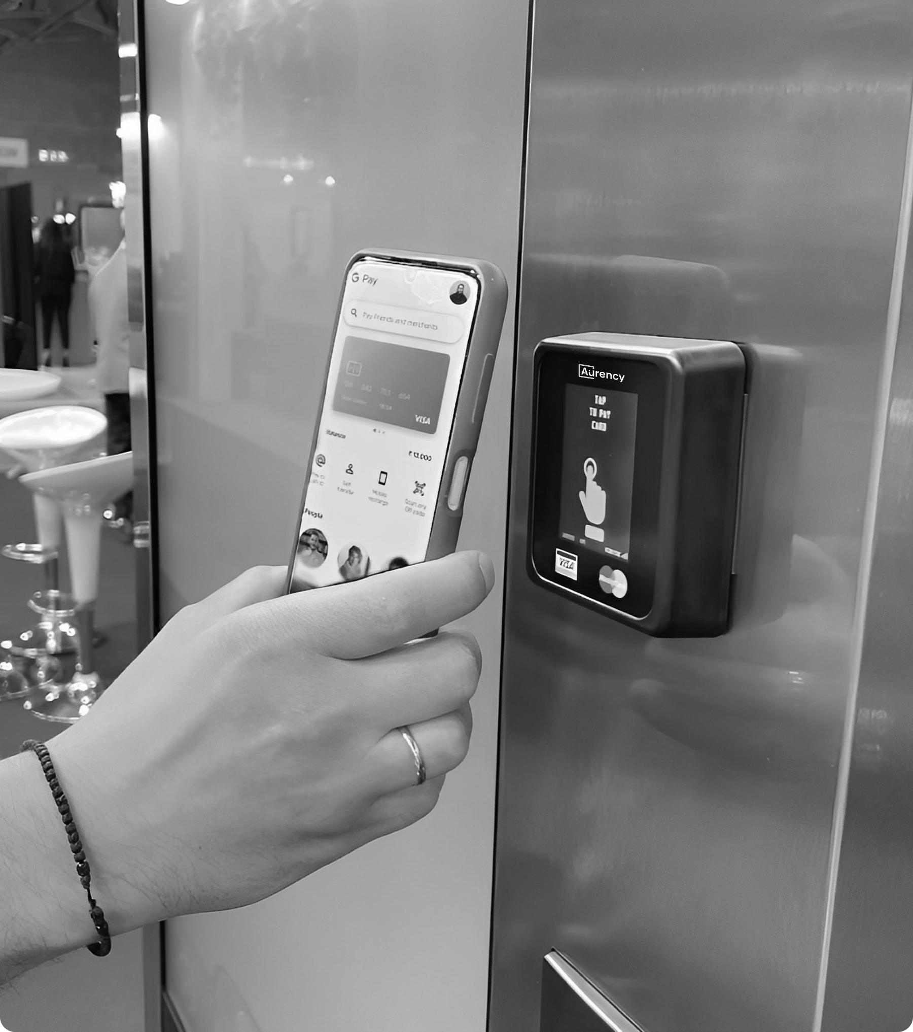 A customer tapping a phone on the Aurency A250 terminal