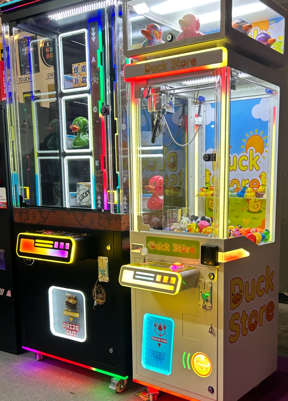 Neon claw machines with a Duck Store cabinet and tap-to-pay reader on the floor