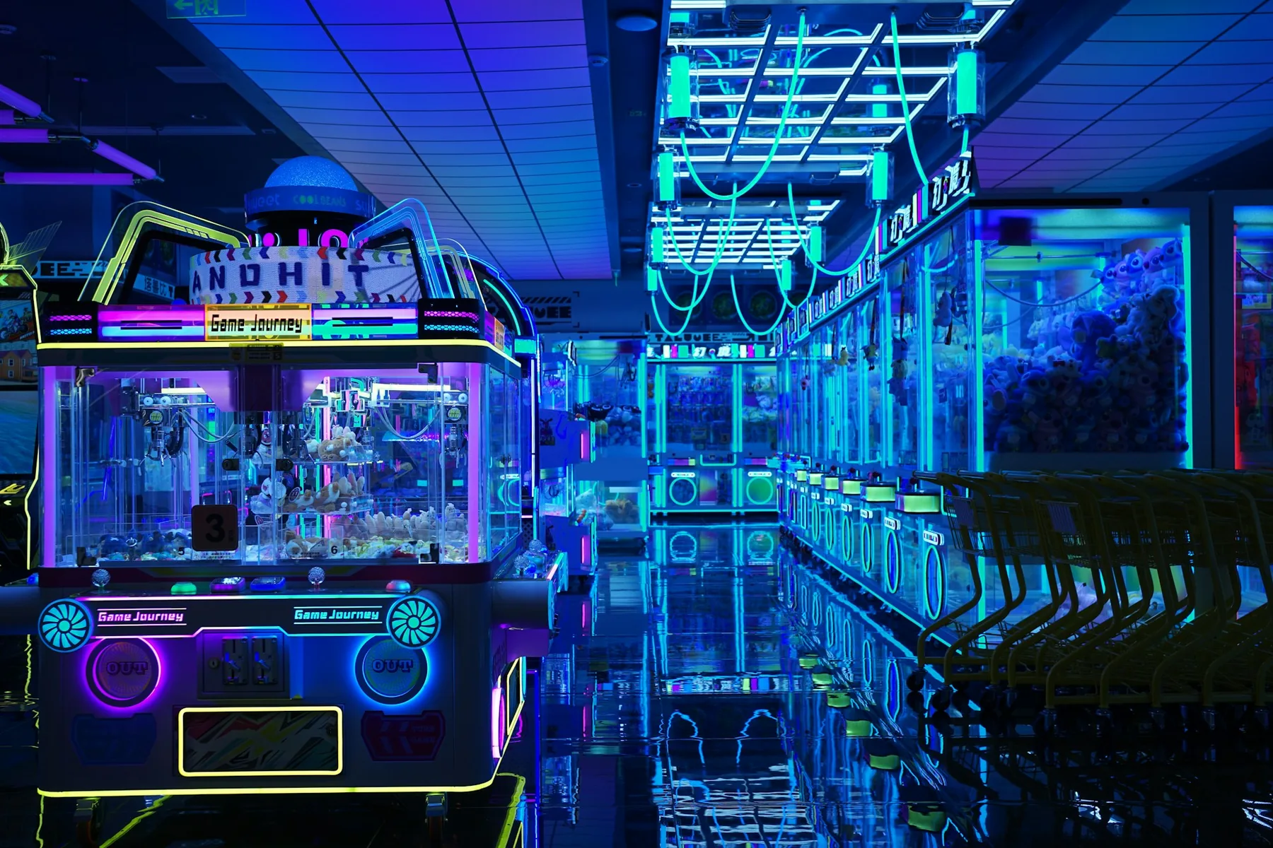 A neon-lit arcade aisle lined with claw machines and prize cabinets