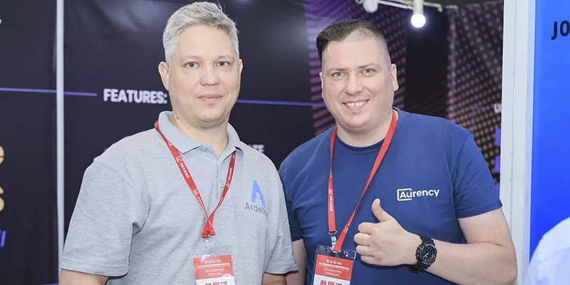 An Aurency team member and an Ardelino team member together at a trade show stand