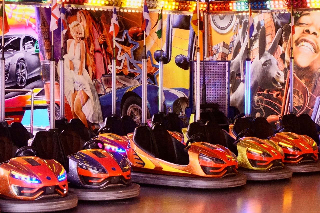Row of illuminated bumper cars in an amusement arcade