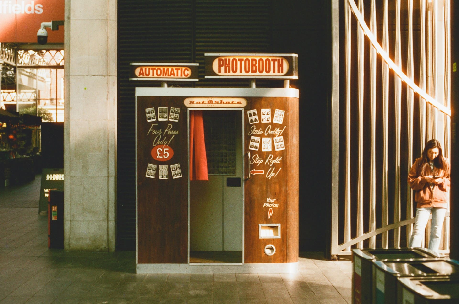 Retro automatic photobooth with red curtain and sample photo strips