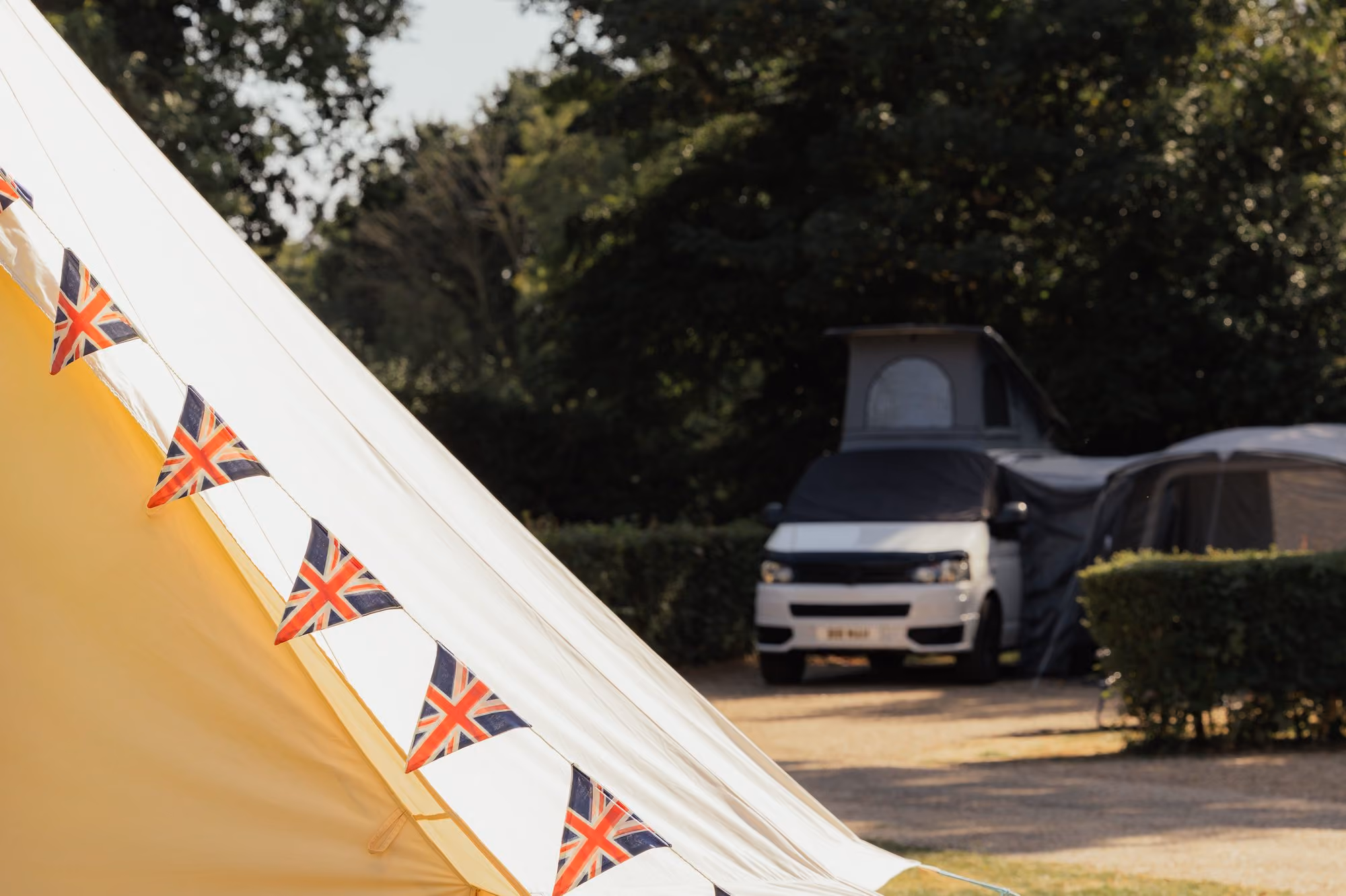 Bell tent and campervan on a camping pitch at Deer’s Mead.