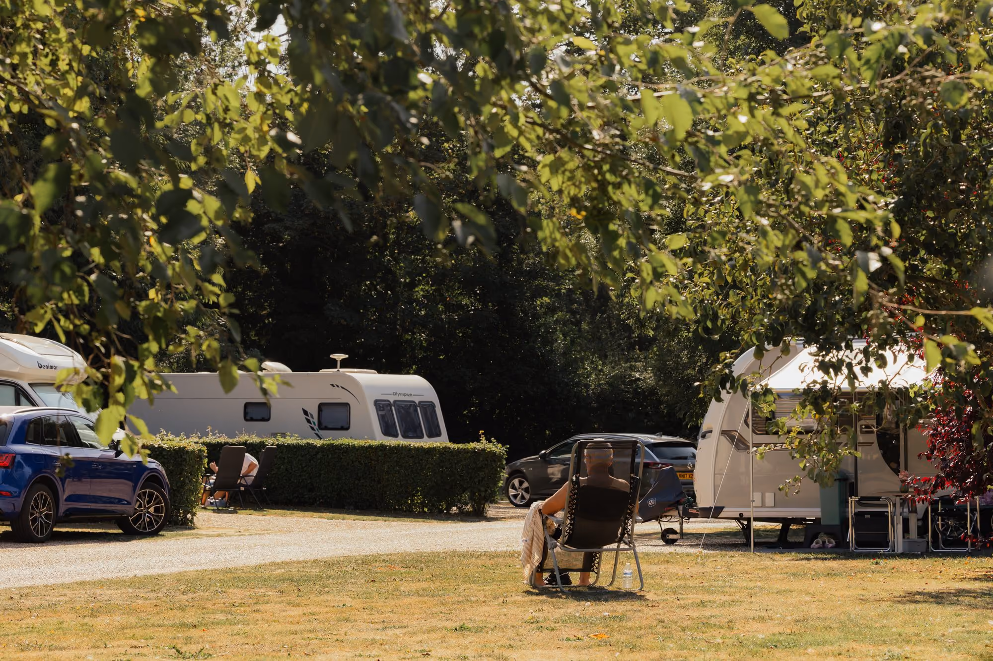 Guest relaxing beside caravans at Deer’s Mead.