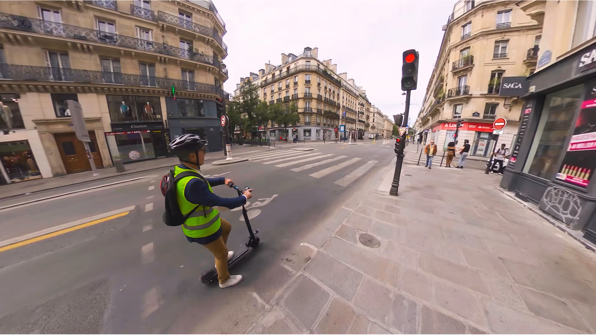 Un utilisateur de trottinette marche sur un trottoir, trottinette à la main, illustrant le module « La signalisation réservée aux trotteurs », qui sensibilise aux règles à suivre pour circuler en toute sécurité dans les espaces partagés.