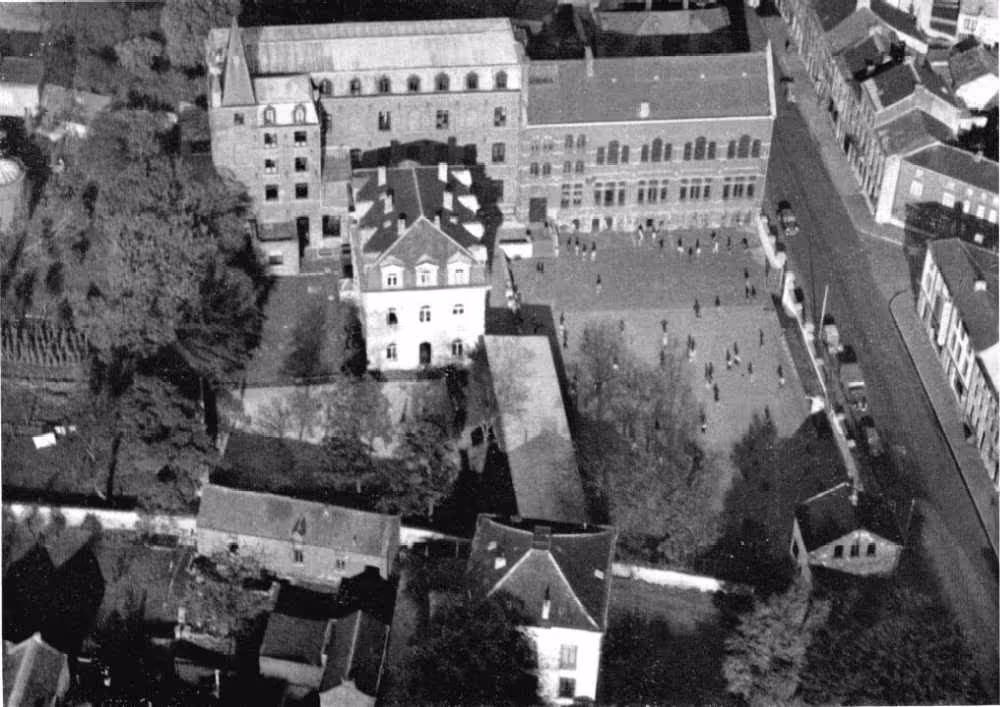 Vue aérienne du Collège Notre-Dame de Bon Secours à Binche :
Cette vue aérienne montre l'ensemble du campus du Collège Notre-Dame de Bon Secours à Binche, mettant en évidence la disposition des bâtiments scolaires, les espaces verts et la cour de récréation. Cette perspective offre une vision complète des installations du collège, soulignant son infrastructure bien conçue pour favoriser un environnement d'apprentissage optimal.