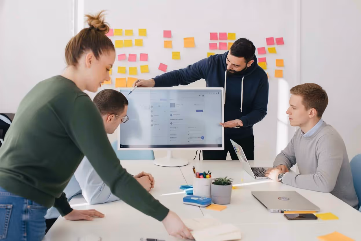 Industrial Intelligence marketing team in a brainstorming session, collaborating in front of a big screen and a post-it wall to design content and demand generation campaigns in the manufacturing sector.