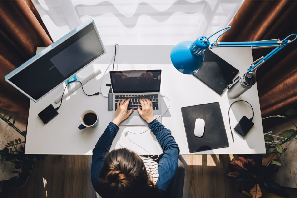 Industrial Intelligence employee teleworking on a hybrid workstation, working on a laptop in an organized home office, a symbol of flexibility and work-life balance.