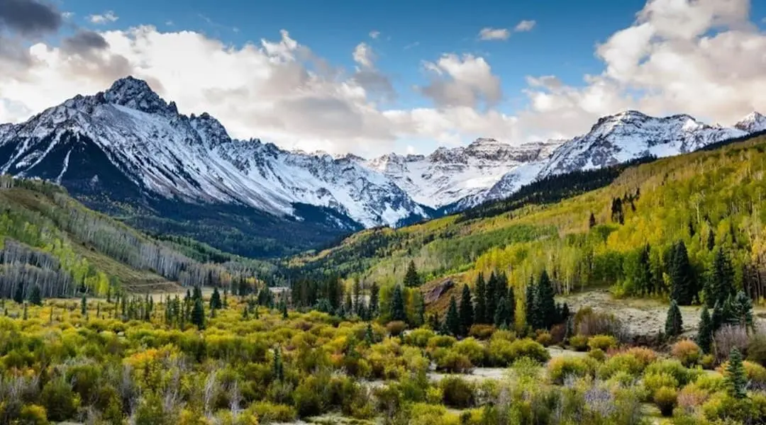 Colorado Rocky Mountains featuring snow-covered peaks, forested valleys, and scenic alpine terrain.
